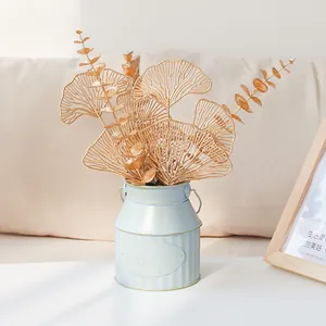 Vaso vintage in ferro azzurro con foglie di ginkgo artificiali dorate per decorazione