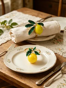 Gros plan d'élégants ronds de serviette citron avec feuilles vertes sur table