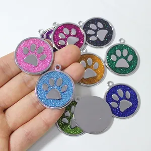 Macro view of colorful glitter 30mm paw print charms for pet ID tags.