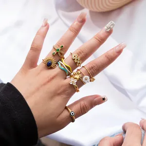 Detail view of 18K gold plated stainless steel rings with zircon and flower motifs on hand.