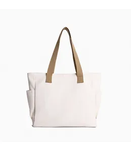 Plain white canvas tote bag with khaki straps and side pockets for daily commute.