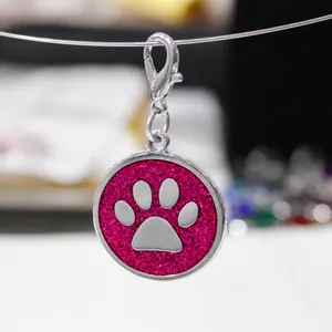 Detailed view of 30mm round pink glitter dog paw print pendant with silver clasp
