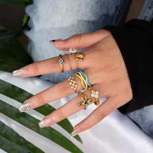 Detailed view of 18K gold plated rings featuring zircon snake and flower motifs on hand.