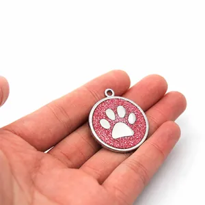 Close-up of 30mm pink glitter pet ID tag with silver paw print design