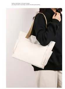 Model carrying a white canvas tote bag with brown straps, showing commute style.