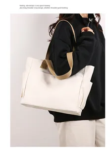 Detailed view of a cream canvas tote bag with khaki straps worn by a model in detail