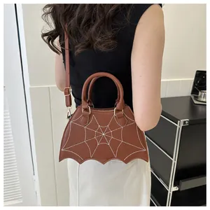 Vista posteriore modella con borsa a tracolla marrone ricamata a ragnatela e pipistrello