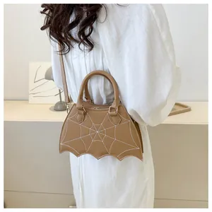 Dettaglio di una borsa in PU marrone a forma di pipistrello con ricamo a ragnatela.