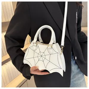 Dettaglio del motivo a ragnatela bianca e fondo a forma di ala di pipistrello su borsa.