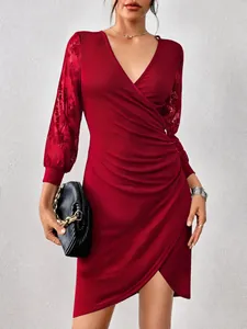 Detailed view of red V-neck dress featuring floral lace sleeves and ruched front design