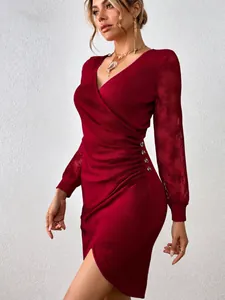 Detail view of an elegant red V-neck dress featuring lace sleeves and side button accents.