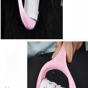 Detail view of pink lint roller removing hair from black knitted fabric texture.