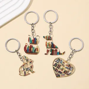 Close-up of cat, dog, and heart shaped acrylic keychains with bookshelf patterns