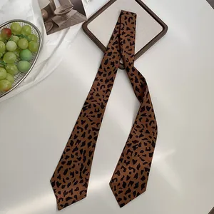 Nahaufnahme eines braunen Seidenschals mit Leopardenmuster und eleganter Textur