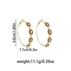 Detailed view of gold rugby ball hoop earrings with 4.8cm diameter and 11.1g weight.