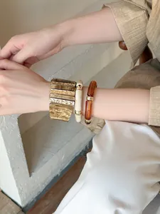 Gros plan de bracelets empilables en acrylique irisé rétro avec accents dorés élégants