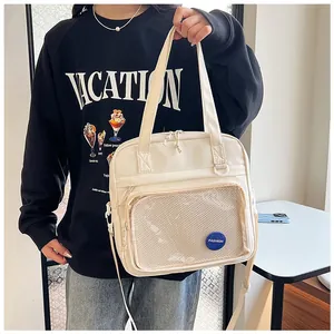 Stylish cream tote bag with mesh pocket and FASHION badge carried by a casual model