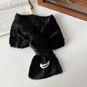 Eleganter schwarzer Kunstfellschal mit weißem Markenlabel auf weißem Hintergrund.