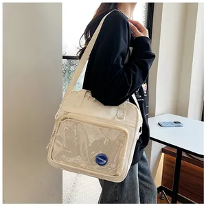 Lifestyle view of a cream crossbody bag with a transparent pocket on a model.