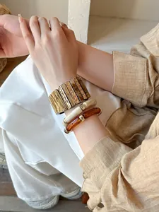 Gros plan de bracelets rétro en acrylique et métal avec texture marbrée sur le poignet