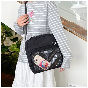 Black student crossbody bag detail featuring a transparent front pocket and model fit.