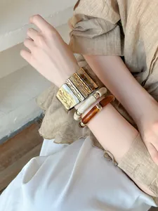 Vue détaillée de bracelets empilables en acrylique irisé rétro sur le bras du modèle.