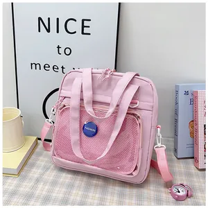 Pink student handbag with transparent mesh pocket and a blue fashion badge detail