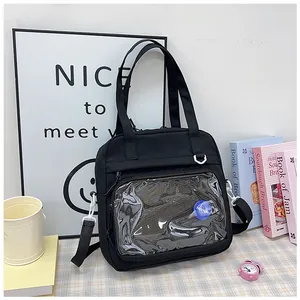 Detail view of a black tote bag featuring a large transparent front pocket design.