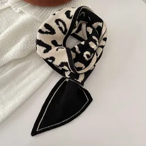 Nahaufnahme eines Strickschals mit markanten schwarz-weißen Buchstabenmustern