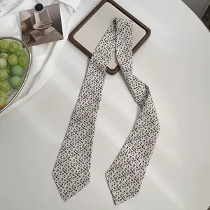 Detailaufnahme eines Satin-Schals mit Leopardenmuster auf einem sauberen weißen Schreibtisch