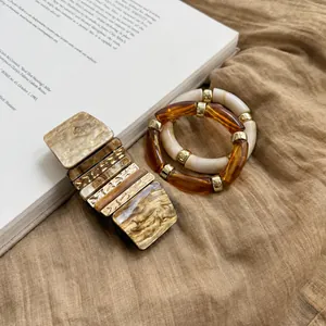Détail de bracelets vintage en acrylique avec texture marbre ambre et accents dorés