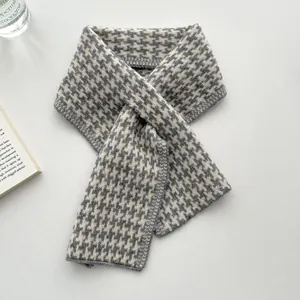 Detailansicht eines weichen Strickschals mit klassischem grauem Hahnentrittmuster.