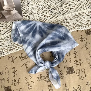Detailansicht eines blau gebatikten Satin-Seidentuchs mit elegantem Knotendetail