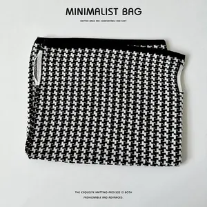Detailansicht eines schwarz-weißen Hahnentritt-Strickmusters auf einem weichen Stoff.