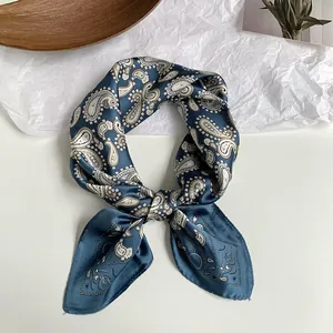 Detailansicht eines blauen Seidenschals mit elegantem Paisley-Muster und Knotendetail