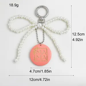 Gedetailleerde weergave van parelboog sleutelhanger met MAMA hanger en afmetingen.