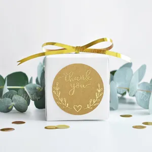 Kraft paper thank you stickers with gold foil olive branch designs on a white gift box