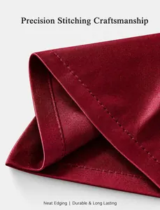 Detail shot showing precision stitching craftsmanship on a smooth dark red satin pillowcase