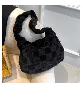 Close-up of a black plush tote bag with a soft checkered texture on a white chair