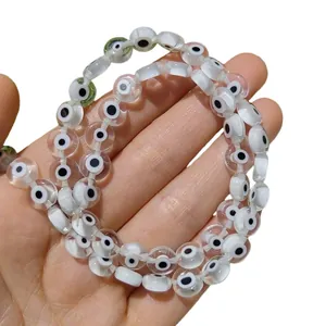 Vue détaillée de perles de verre œil de démon plates et rondes pour bijoux artisanaux.