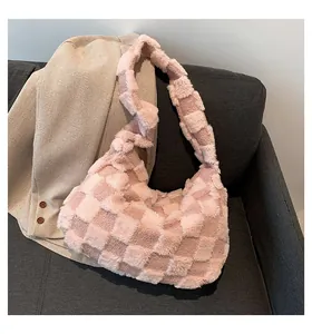 Detailed close-up of a pink plush checkered tote bag on a stylish grey sofa background