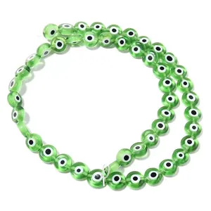 Détail en gros plan de perles œil de verre vert plat translucides pour bijoux faits main.