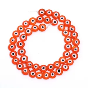 Vue détaillée de perles en verre orange Evil Eye pour la création de bijoux DIY
