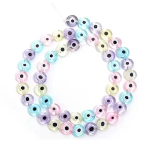 Détail de perles en verre œil grec plates et colorées pour création de bijoux DIY