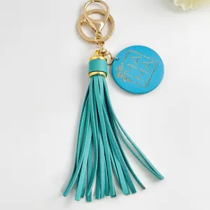 Detailopname van een groenblauwe PU-lederen kwastjes-sleutelhanger met MAMA-hanger