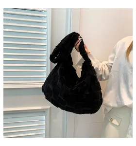 Detail of large black furry tote bag with checkered texture being held