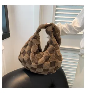 Close-up handheld view of a large brown checkered plush tote bag with a soft texture