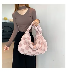 Detail view of a soft plush checkered tote bag in pink tones, perfect for winter fashion.
