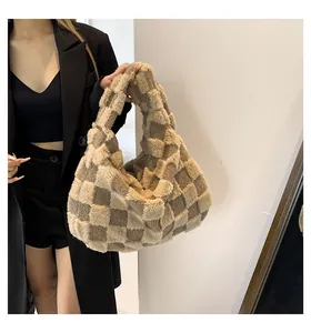 Detailed view of a model holding a plush checkerboard tote bag with a soft texture