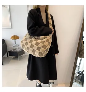 Large checkered plush tote bag shown on model in a stylish indoor lifestyle setting